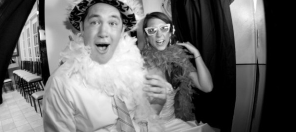 wedding guests in photo booth with silly hats and funny faces