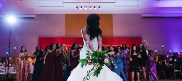 bride tossing bouquet after choosing best wedding DJ and asking wedding DJ questions